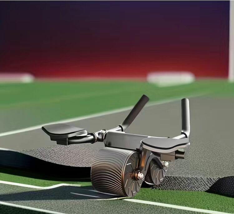 Ab Roller mit Griffen auf Sportmatte, Fitnessgerät für Bauchmuskeltraining, schwarz-grau.