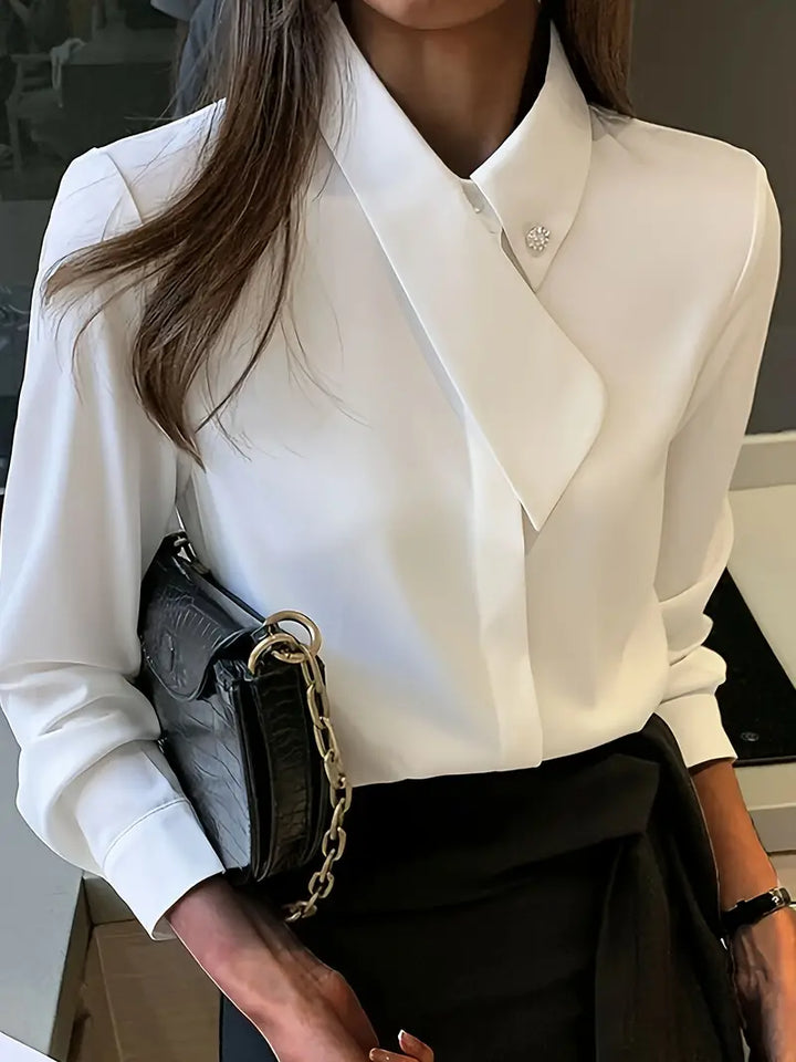 Frau in weißer Bluse mit schwarzer Tasche, elegantes Business-Outfit, Büro-Mode.
