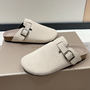 Beige Wildleder-Pantoletten mit Schnalle auf Schuhkarton, modische Damen-Slipper.