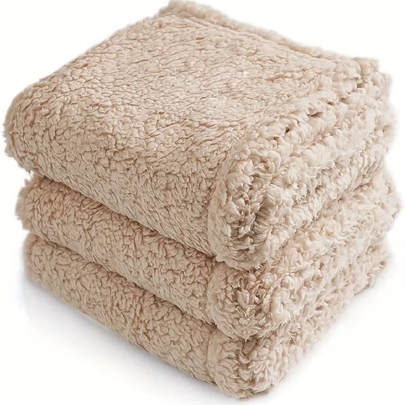 Beige Kuscheldecke aus Fleece, dreifach gestapelt, weich und warm, ideal für Sofa oder Bett.