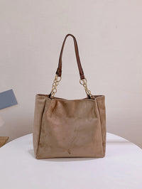 Beige Damenhandtasche aus Wildleder mit Kettenriemen, elegant und modisch.