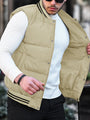 Mann mit beiger Steppweste und weißem Pullover, modische Herrenbekleidung, Outdoor-Stil.