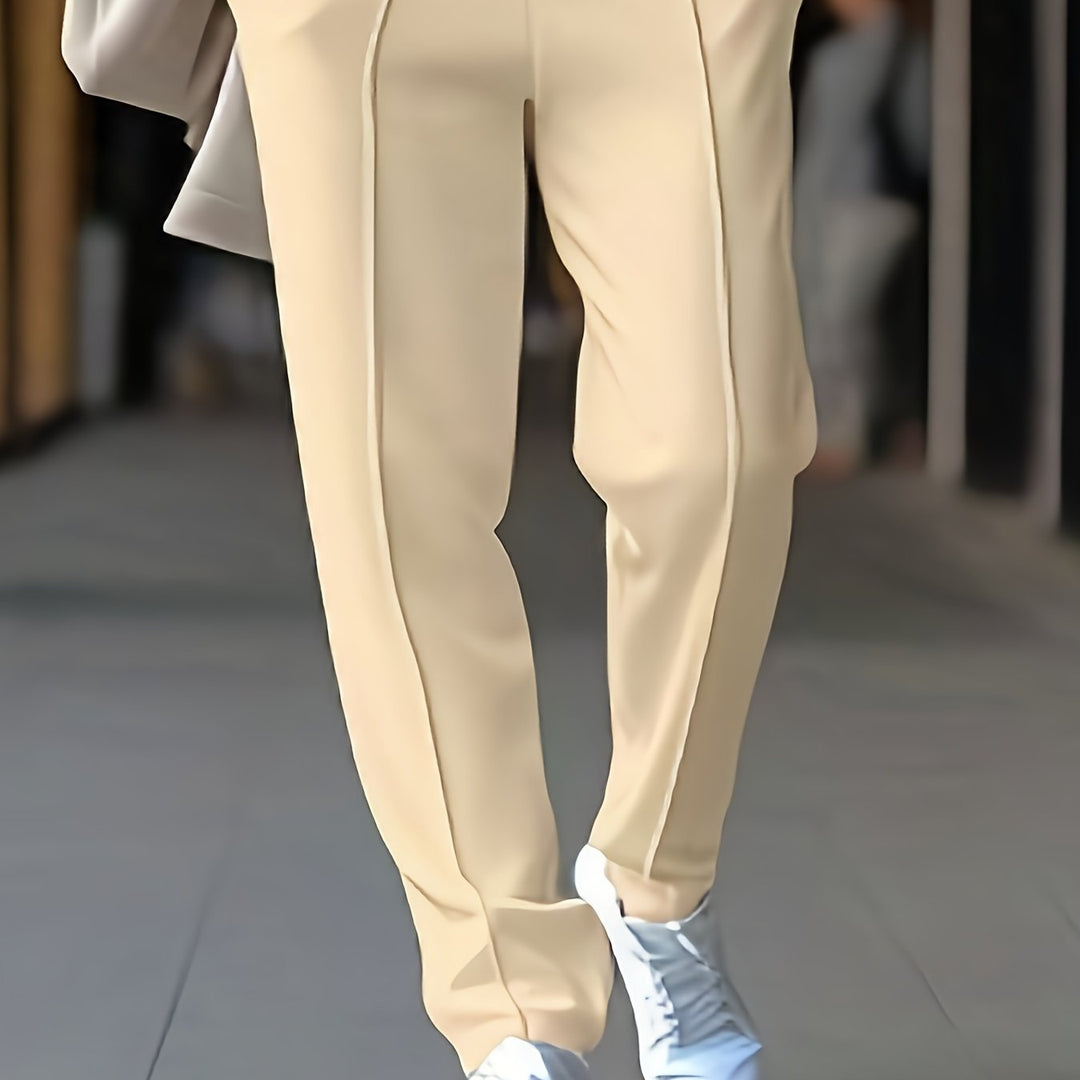 Beige Damenhose, elegant, gerade geschnitten, aus Baumwolle, kombiniert mit weißen Sneakers.