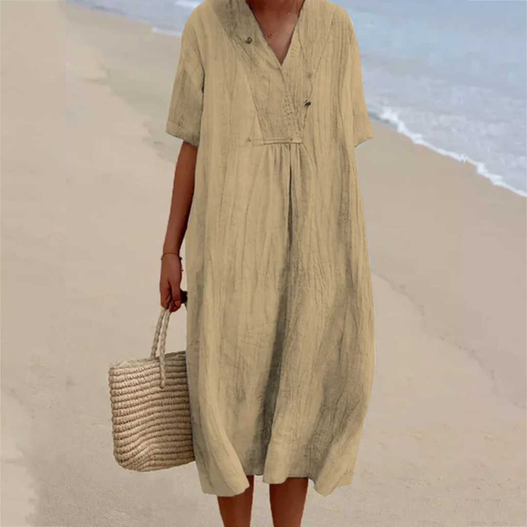 Frau im beige Leinenkleid am Strand mit Strohtasche, Sommermode, lässiger Stil.