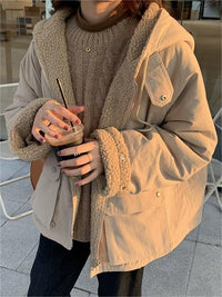 Frau in beiger Teddyjacke mit Kapuze hält Eiskaffee, Wintermode, gemütlicher Stil.