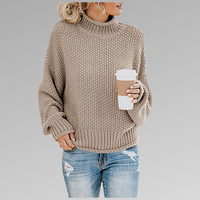 Frau in beigem Strickpullover mit Kaffeebecher, lässige Mode, Herbstoutfit, grauer Hintergrund.