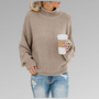 Frau in beigem Strickpullover mit Kaffeebecher, lässige Mode, Herbstoutfit, grauer Hintergrund.