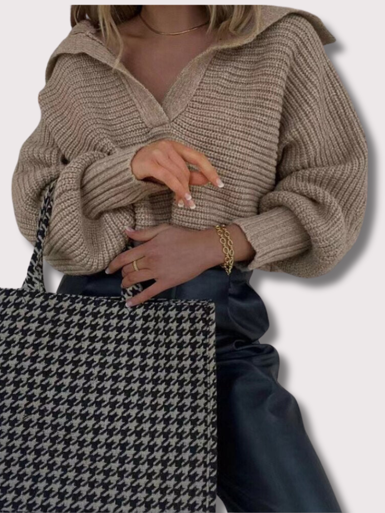 Frau mit beigem Strickpullover und Hahnentritt-Tasche, modisch, elegant, Herbstmode.