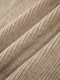 Beiger Strickstoff, Nahaufnahme, weiche Textur, hochwertige Wolle, Mode, Bekleidungsmaterial.