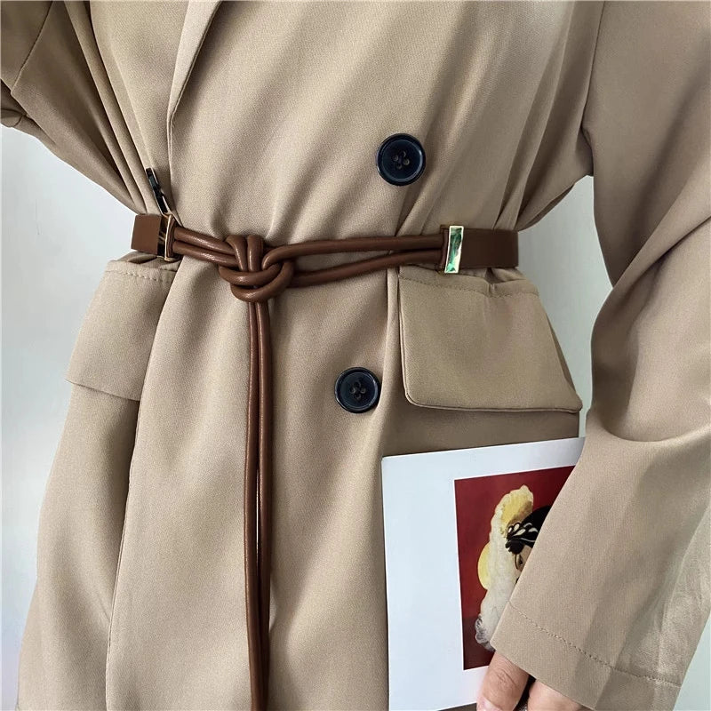 Beiger Trenchcoat mit braunem Gürtel, doppelte Knopfleiste, elegantes Design, Damenmode.