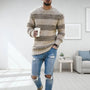 Mann in beige gestreiftem Strickpullover, zerrissene Jeans, hält Kaffeetasse, modernes Wohnzimmer.