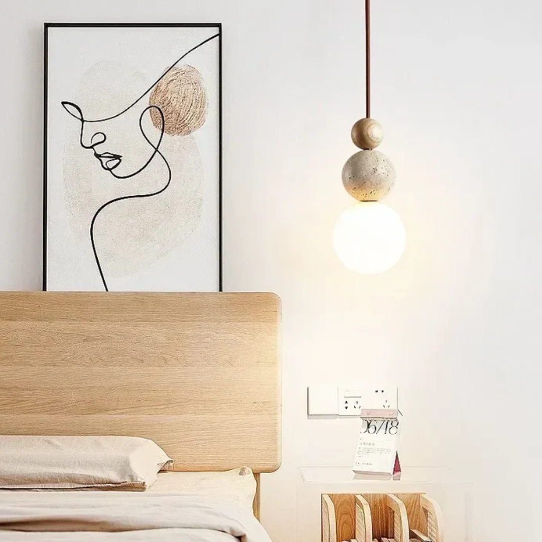 Holzbettrahmen mit minimalistischer Kunst und moderner Hängelampe im Schlafzimmer.