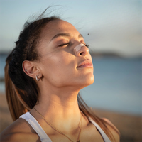 Frau mit Nasenstrips am Strand, Entspannung, Atemhilfe, Hautpflege, Sommer, Sonnenuntergang.
