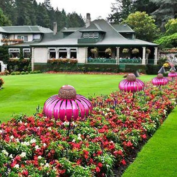 Rosa Metall-Vogelfutterspender im Garten, dekorativ, wetterfest, ideal für Vögel anlocken.