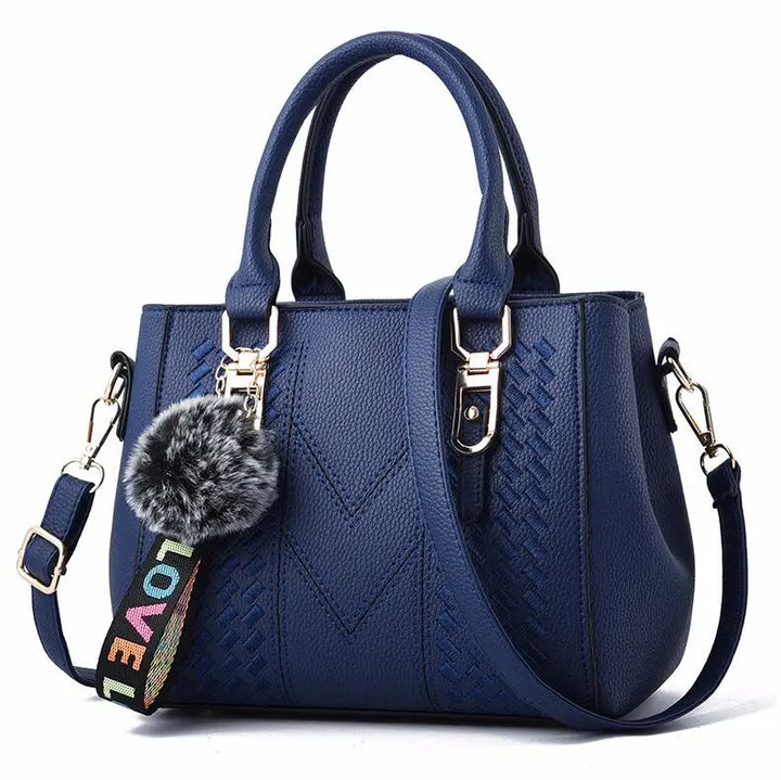 Blaue Damenhandtasche mit Schulterriemen, Kunstleder, Pompon-Anhänger, modisch, elegant.