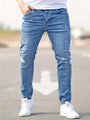 Mann in blauer Jeans und weißen Sneakers auf Straße, modische Freizeitkleidung, urbaner Stil.