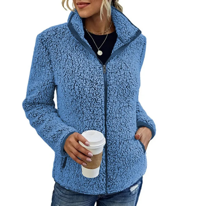 Frau in blauer Fleecejacke mit Kaffeebecher, lässige Wintermode, Damenbekleidung.