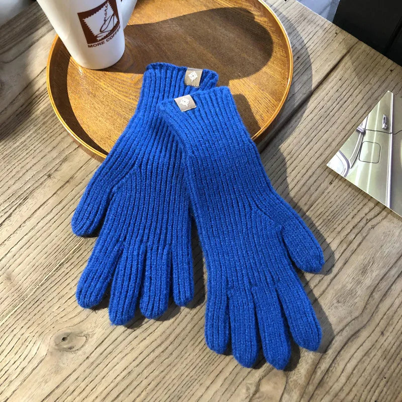 Blaue Strickhandschuhe aus Wolle auf Holztisch, Wintermode Accessoire, warm und stilvoll.