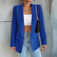 Frau in blauem Blazer, weißem Top, Jeans, schwarze Tasche, modisch, elegant, Streetstyle.