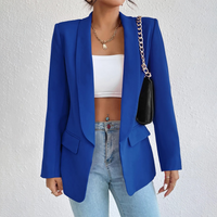 Frau in blauem Blazer, weißem Top, Jeans, mit schwarzer Tasche, modisch, Büro-Outfit.