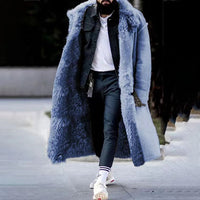 Mann in blauem Kunstpelzmantel, schwarze Jeans, weiße Sneakers, modischer Winterlook.