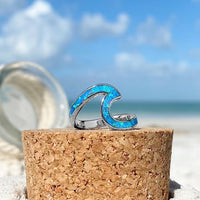Silberring mit blauem Opal, Wellenform, auf Kork, Strandhintergrund, Schmuck, Damenring.