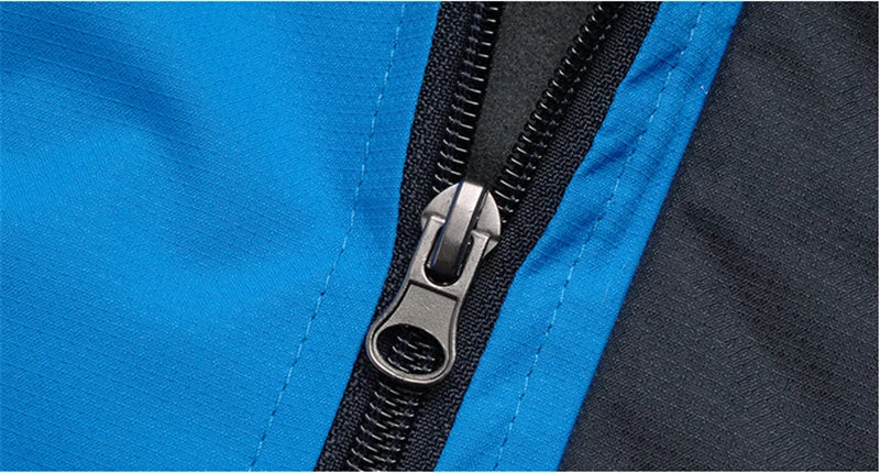 Blauer Reißverschluss an Outdoor-Jacke, wasserabweisend, robust, Nahaufnahme.