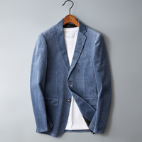 Blauer Cord-Blazer für Herren, elegant, mit weißem T-Shirt, auf Kleiderbügel.
