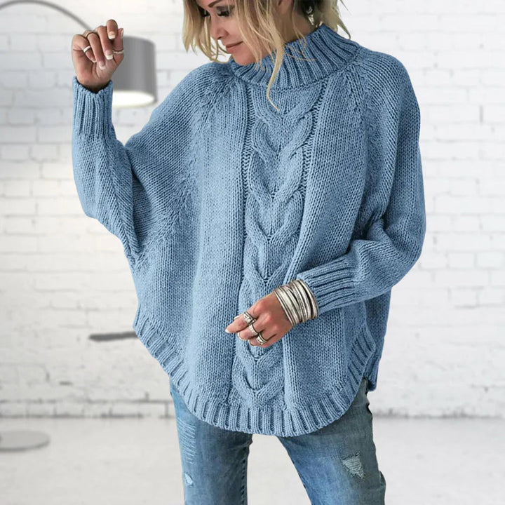 Frau in blauem Strickpullover mit Zopfmuster, lässiger Stil, modische Damenbekleidung.