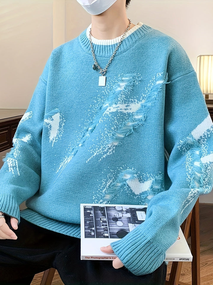 Person in blauem Strickpullover mit abstraktem Muster, hält ein Buch, modisch, lässiger Stil.