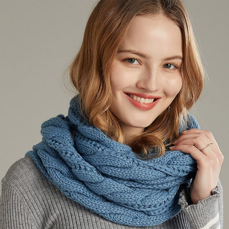 Frau mit blauem Strickschal, lächelnd, grauer Pullover, modisches Winteraccessoire.