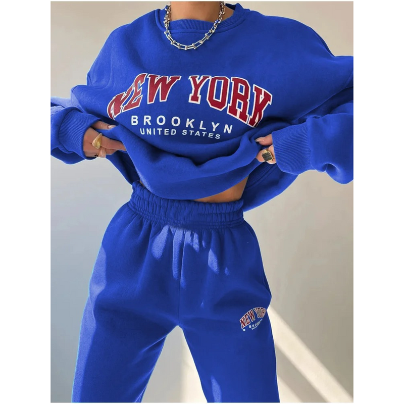 Frau in blauem "New York Brooklyn" Sweatshirt und Jogginghose, lässige Mode, Streetwear.