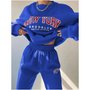 Frau in blauem "New York Brooklyn" Sweatshirt und Jogginghose, lässige Mode, Streetwear.