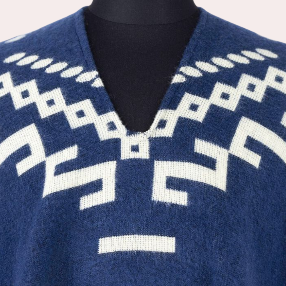 Blauer Alpaka-Poncho mit weißem geometrischem Muster, V-Ausschnitt, weiches Material.