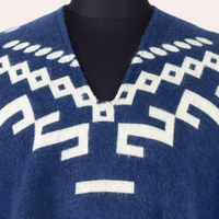 Blauer Alpaka-Poncho mit weißem geometrischem Muster, V-Ausschnitt, weiches Material.