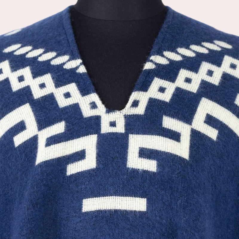Blauer Alpaka-Poncho mit weißem geometrischem Muster, V-Ausschnitt, weiches Material.