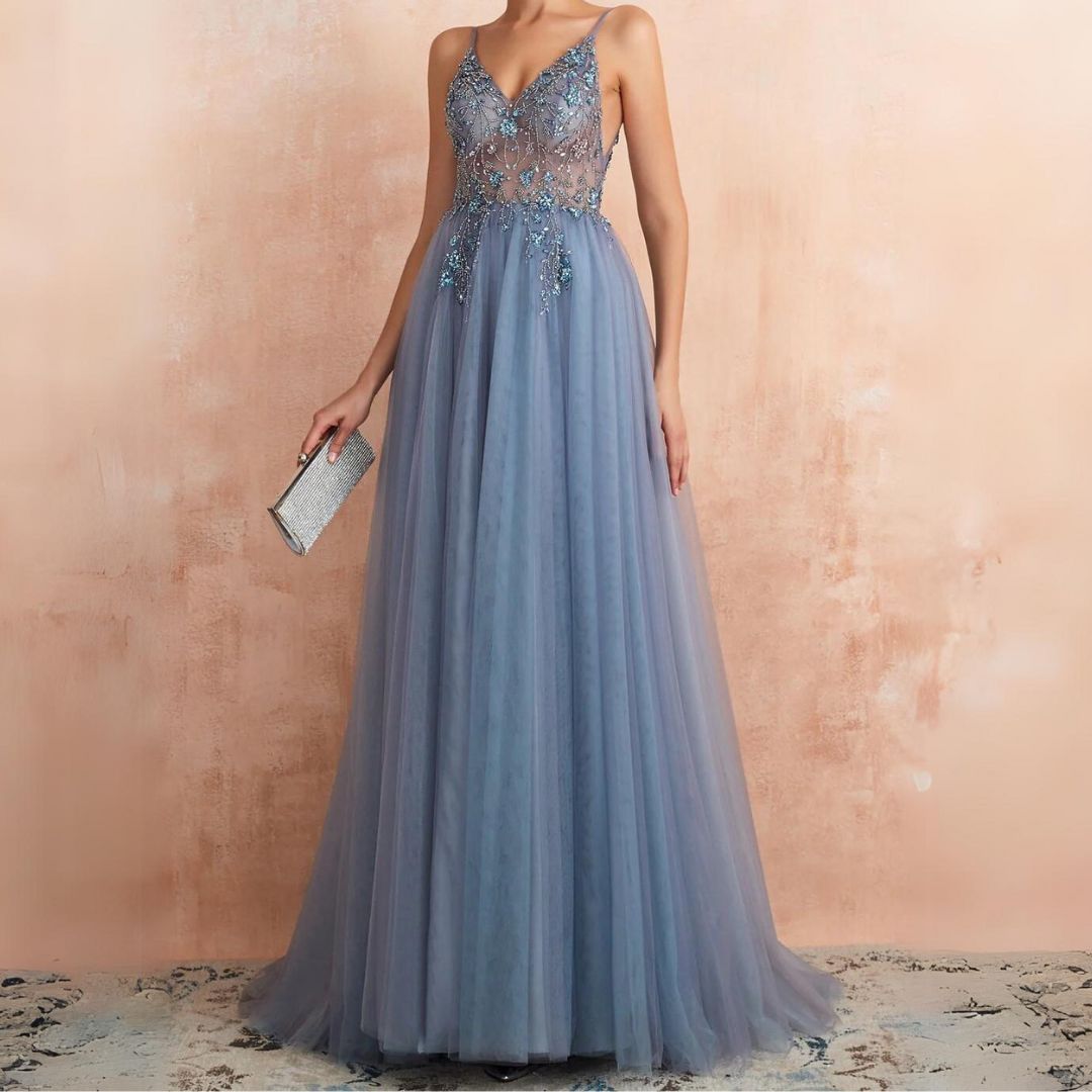 Frau in blauem Abendkleid mit Spitze, hält silberne Clutch, elegantes Design, Abendmode.