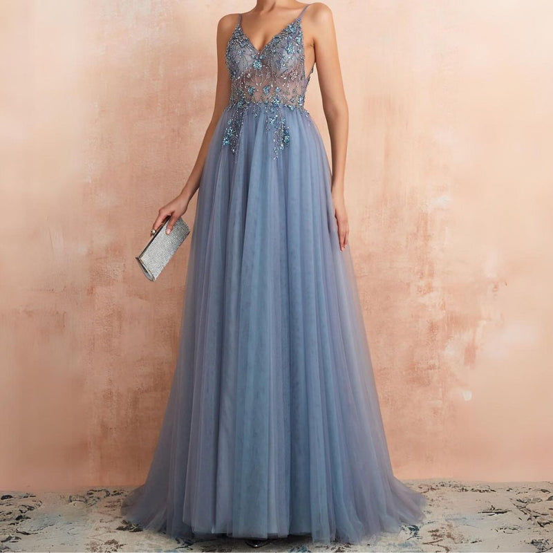 Frau in blauem Abendkleid mit Spitze, hält silberne Clutch, elegantes Design, Abendmode.