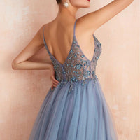 Frau in blauem Abendkleid mit Spaghettiträgern und floraler Stickerei, elegantes Design.