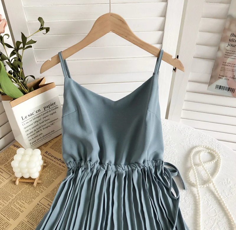 Blaues Sommerkleid mit Spaghettiträgern, Plissee-Design, auf Holzkleiderbügel.