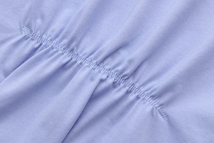 Hellblauer Baumwollstoff mit elastischer Raffung, Nahaufnahme, Textilstruktur, Mode.