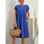 Frau in blauem Baumwollkleid, A-Linie, mit Strohtasche, Sommermode, Boho-Stil.