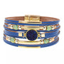 Blaues Lederarmband mit goldenen Akzenten und blauem Kristall, modisches Schmuckstück.