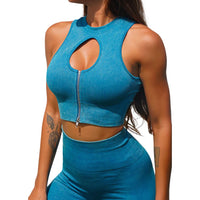 Frau in blauem, ärmellosem Crop-Top mit Reißverschluss und Cut-Out, sportlich, modisch.