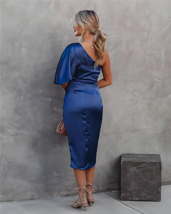 Frau in blauem Satin-Etuikleid mit asymmetrischem Ausschnitt, elegante Abendmode.
