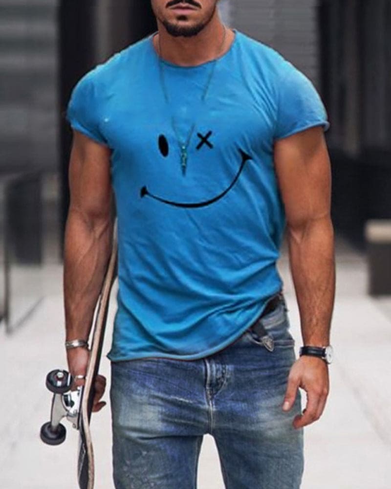 Mann in blauem T-Shirt mit Smiley-Design, Jeans, Skateboard, urbaner Hintergrund.