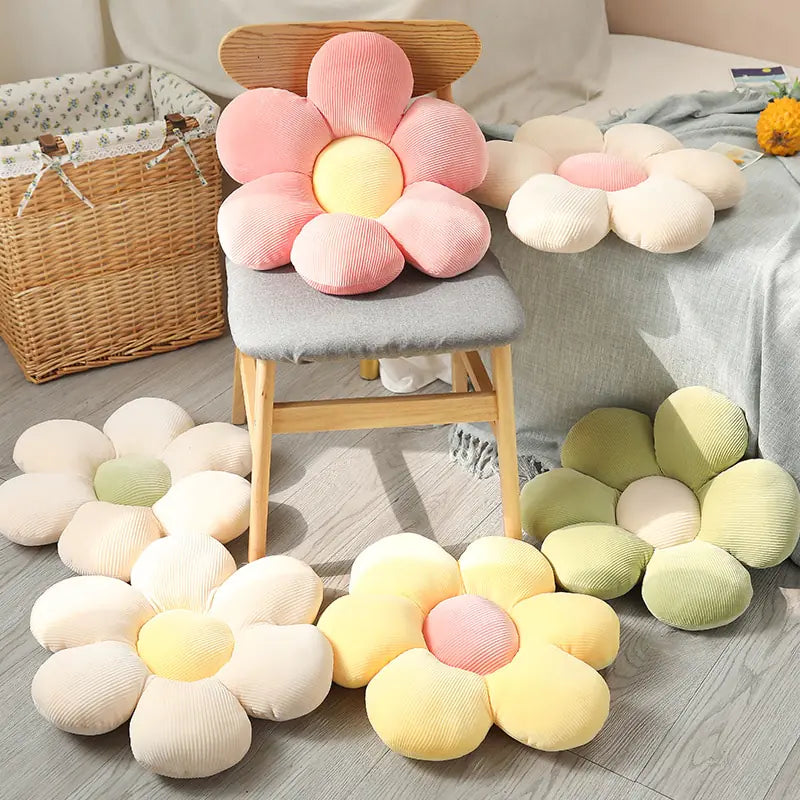 Blumenförmige Kissen in Pastellfarben auf Stuhl und Boden, dekorative Wohnaccessoires.