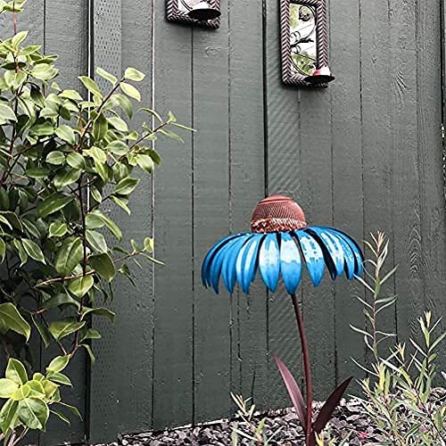 Blumenförmiges Vogelhaus aus Metall, blau, im Garten vor Holzzaun, dekorative Gartendeko.