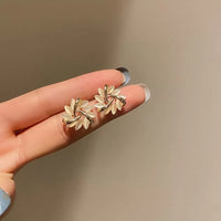 Goldene Ohrringe mit Blumenmotiv, eleganter Schmuck, Damenaccessoire, stilvoll und modern.