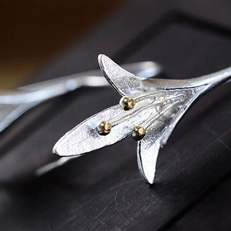 Silberne Blumenohrringe mit goldenen Akzenten, eleganter Schmuck für Frauen, festlich.